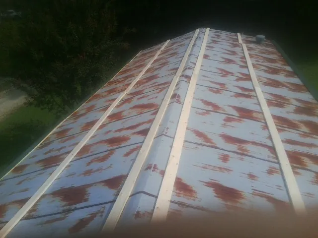 Rusted metal roof panels with new wood purlins before replacement — Storm Damage Roof Repair in Brodnax by Roofing Brothers